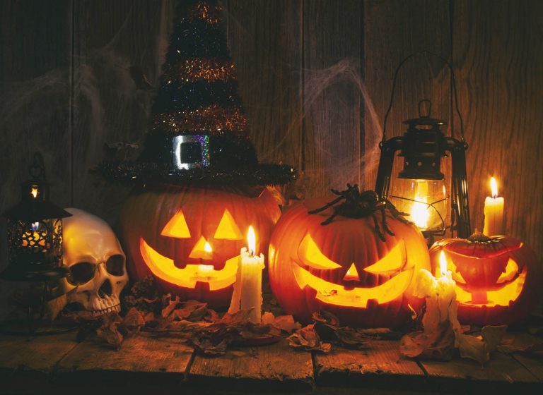 Halloween Jack-o-Lantern Pumpkins on rustic wooden background